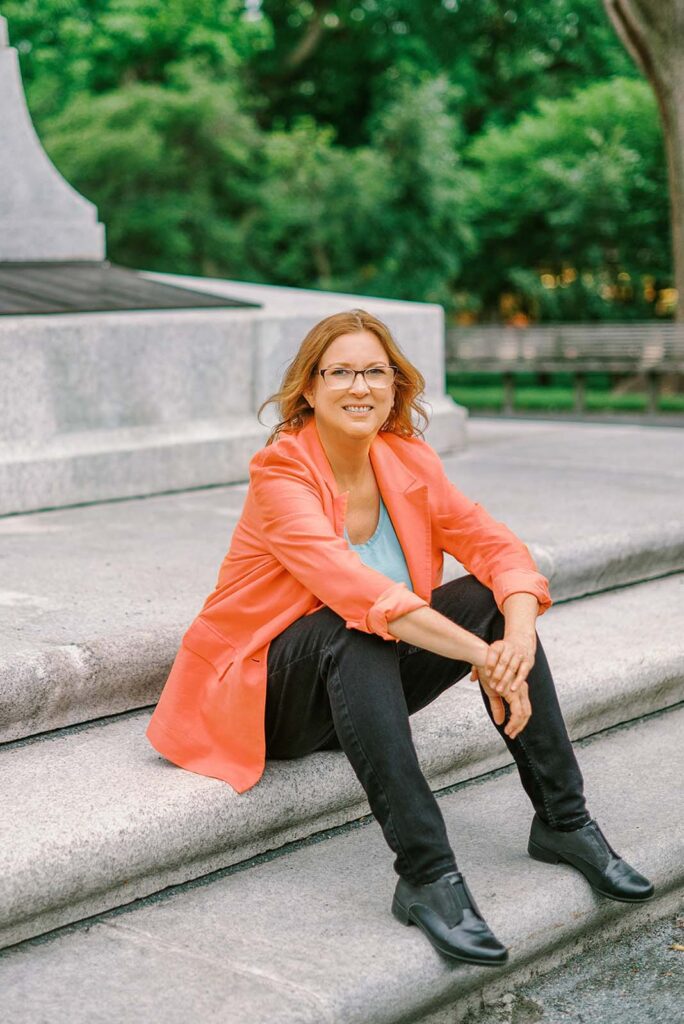 A woman sitting on steps in front of a building.